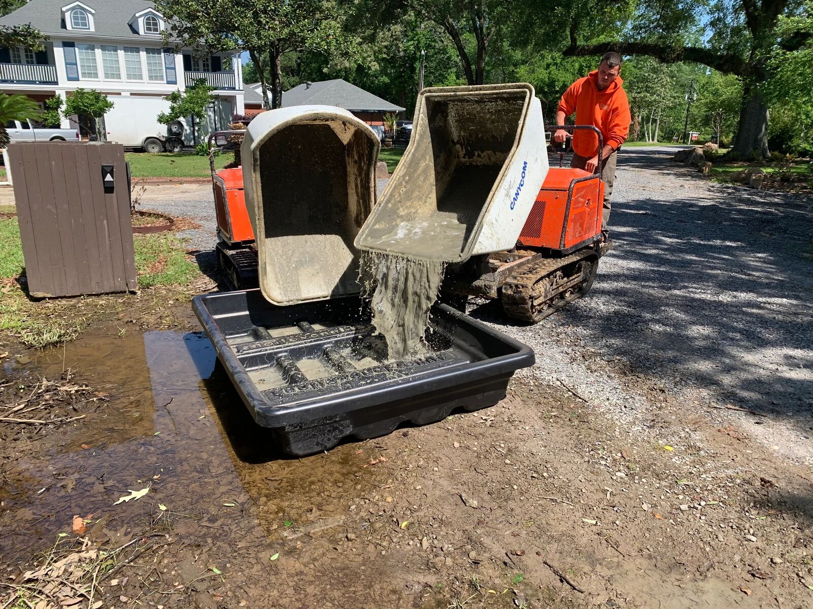 A tracked concrete buggy discharging washout into a Concrete Washout Recyclers basin